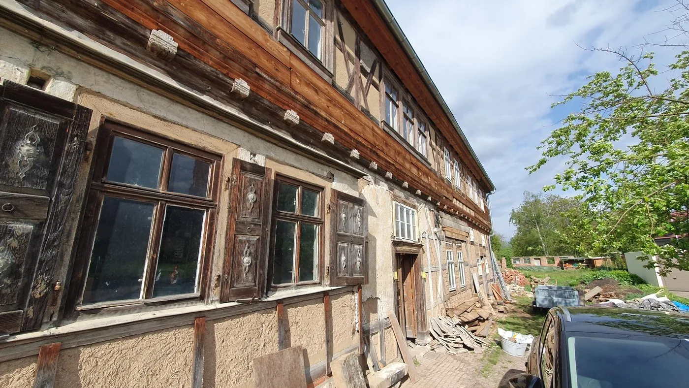 Nahaufnahme der Fachwerkkonstruktion mit historischer Haustür und verwitterten Gefachen