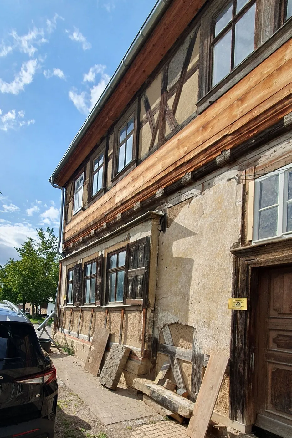 Längsseite des Fachwerkhauses mit originalen Fenstern, freigelegtem Ständerwerk und ausgebesserten Gefachen