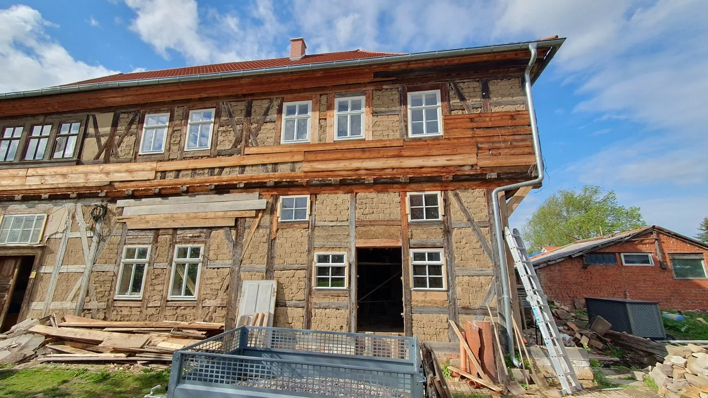 Straßenfassade des Fachwerkhauses vor der Sanierung, freigelegtes Fachwerk und Gefachfüllungen aus Bruchstein